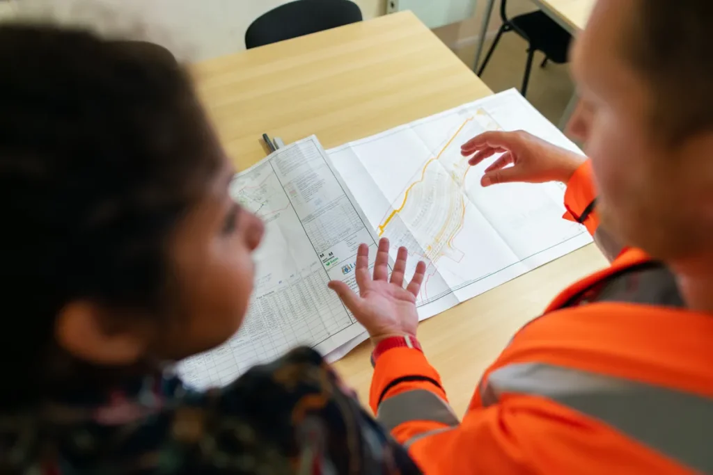 Two engineers reviewing construction drawings on a table